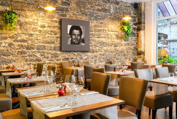 Salle du restaurant italien L’Aurora à Genève avec mur en pierre et ambiance chaleureuse